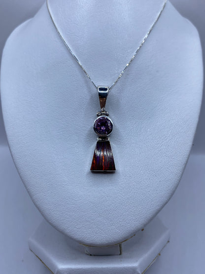 Detalle del ópalo multicolor engastado en plata, mostrando los tonos rojo, naranja y amarillo