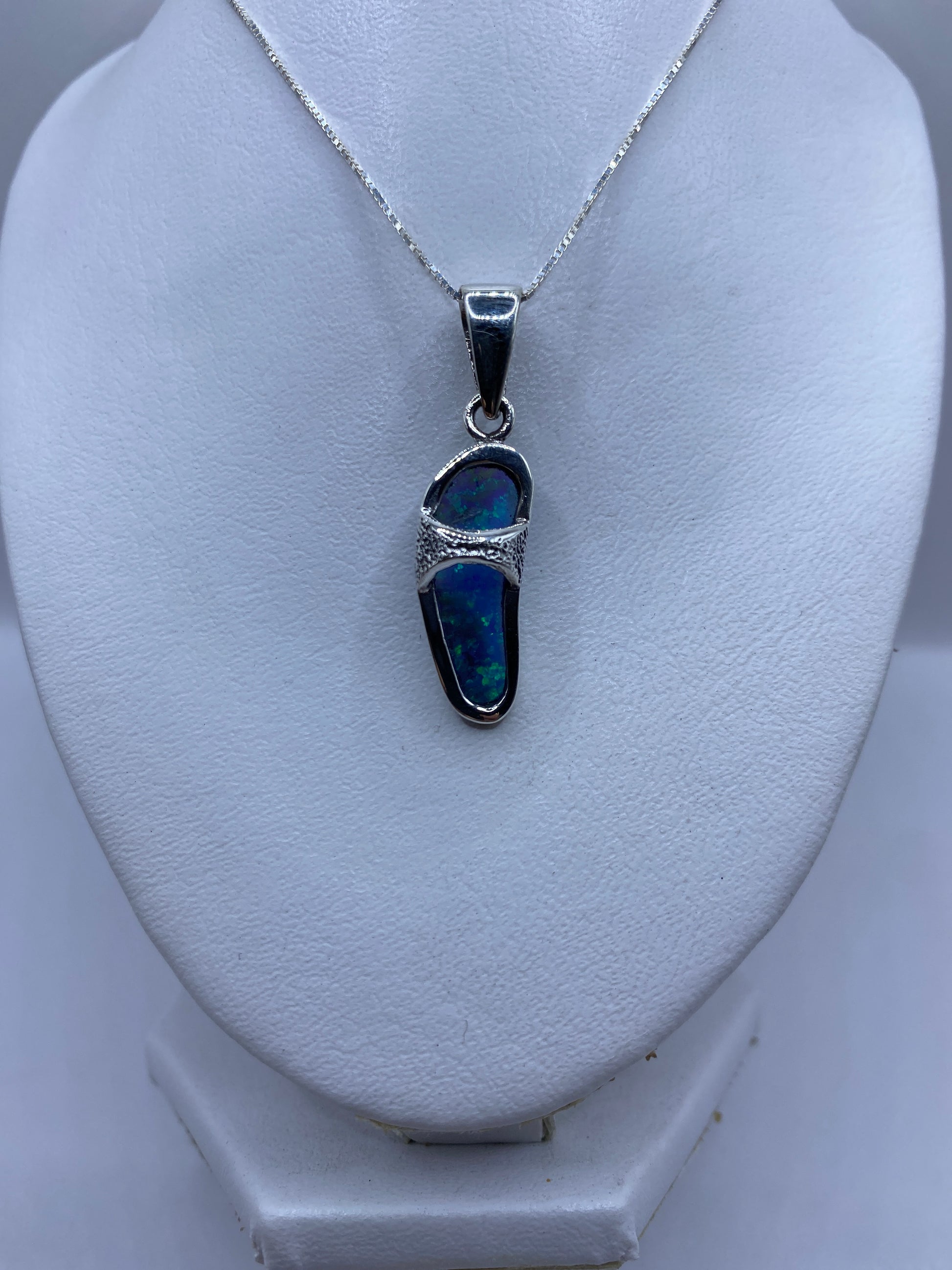 Detalle del engaste a mano y el brillo del ópalo de Fuego con tonos azules