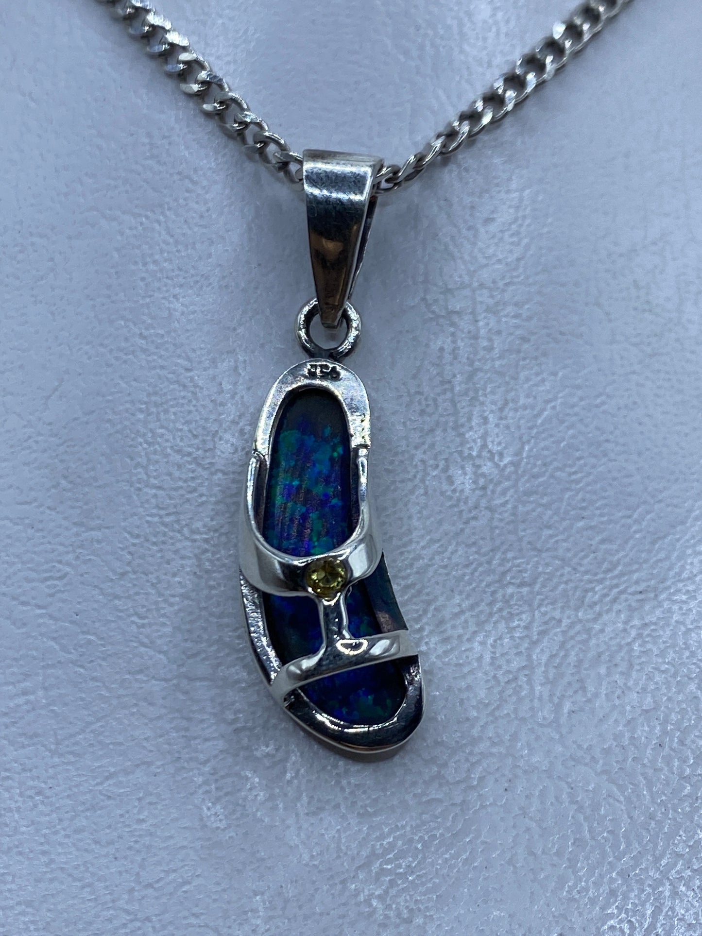 Dije de plata .950 con ópalo de fuego azul, engaste escultórico de Taxco, colgado de cadena plateada