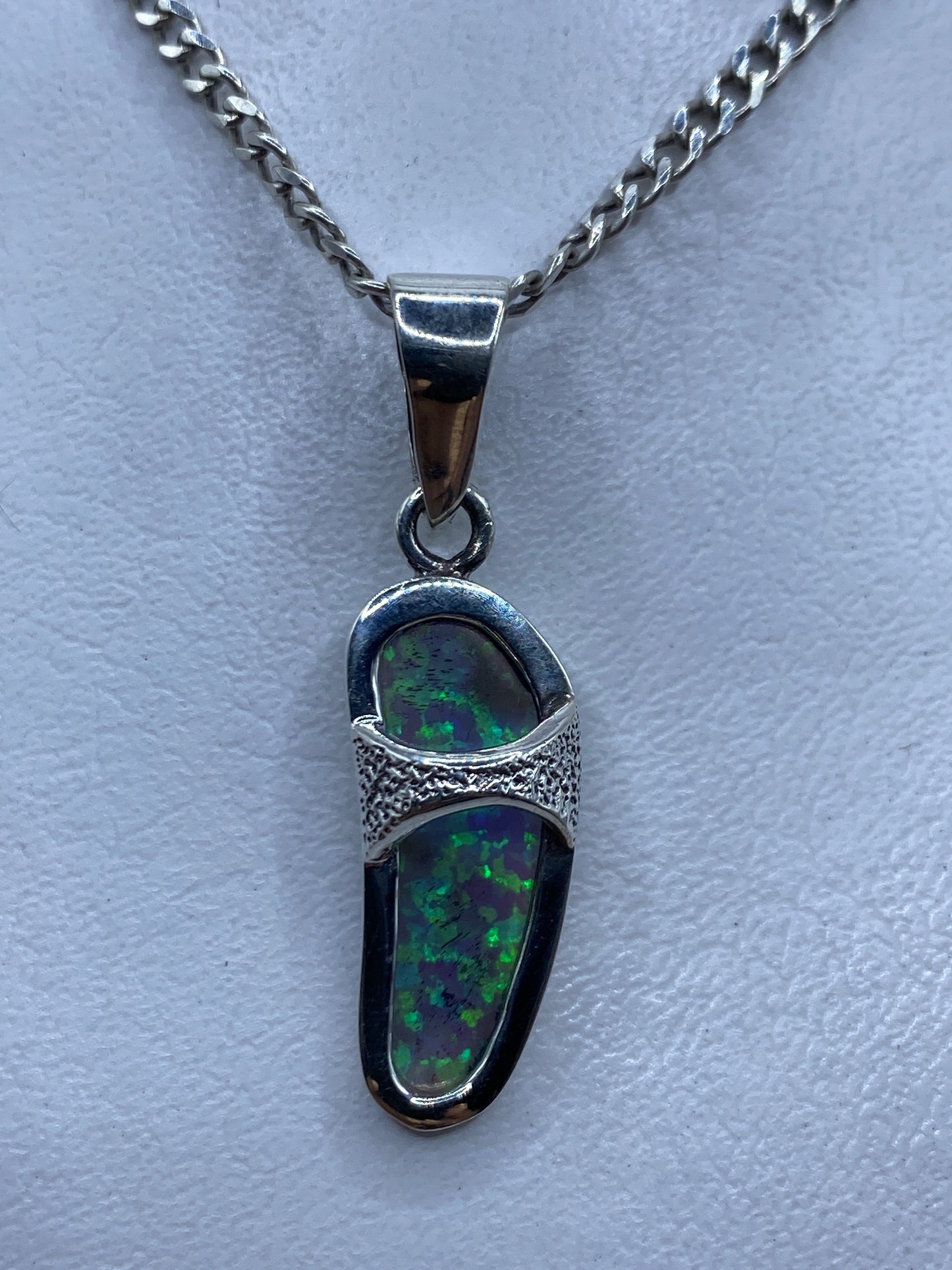 Dije de plata .950 con ópalo de fuego azul en forma alargada, visto de frente