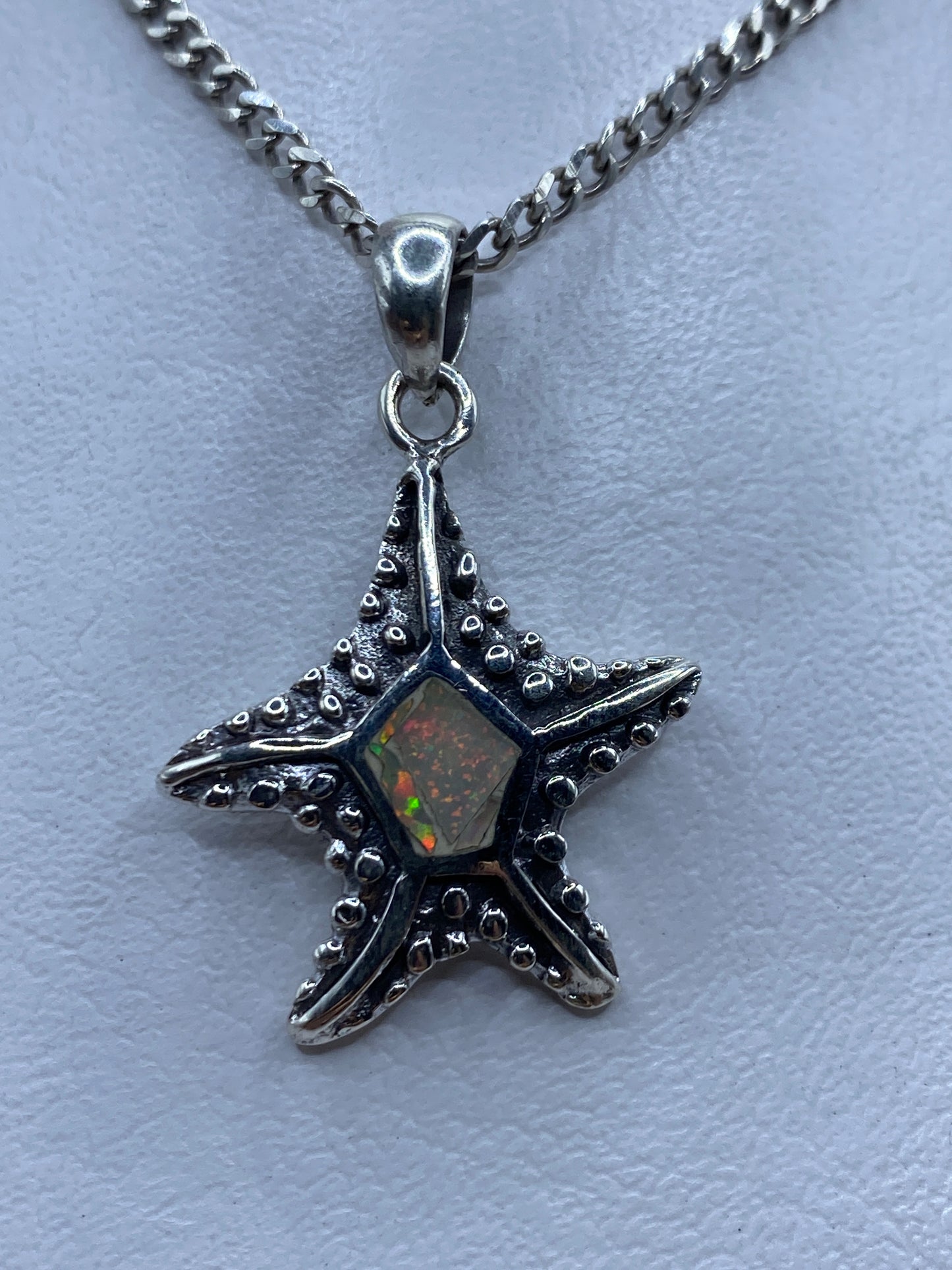 Dije de estrella marina en plata .950 con Ópalo de Fuego multicolor colgando de una cadena curb