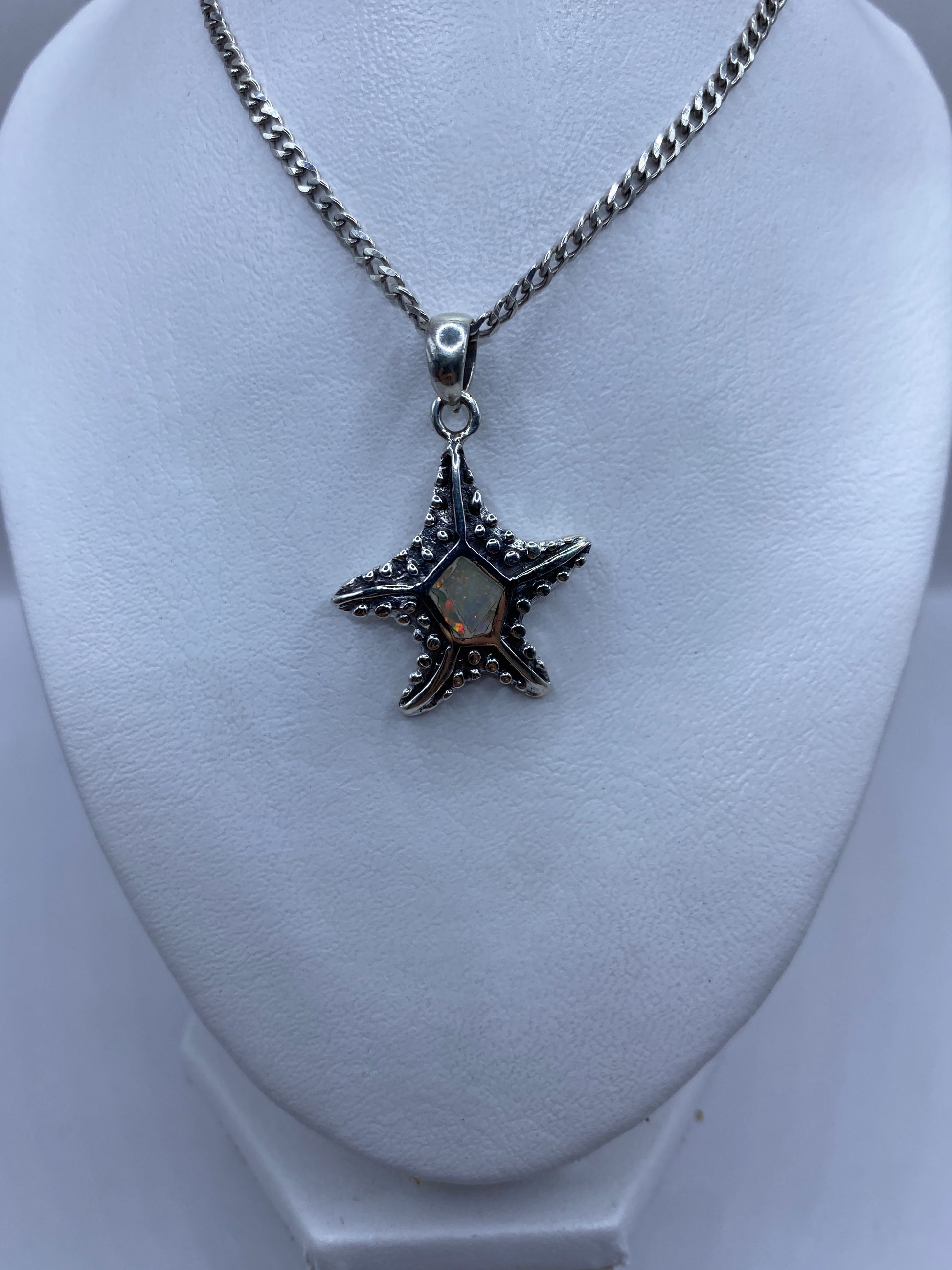 Detalle de la estrella marina de plata .950 con granulado artesanal y Ópalo de Fuego engastado