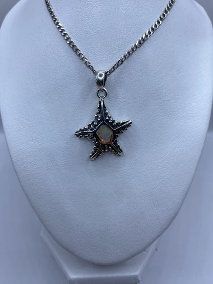 Detalle de la estrella marina de plata .950 con granulado artesanal y Ópalo de Fuego engastado