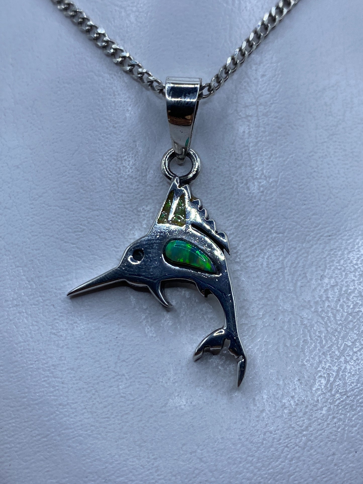 Dije de pez espada en plata .925 con ópalo de fuego verde en el ojo, colgado de cadena plateada