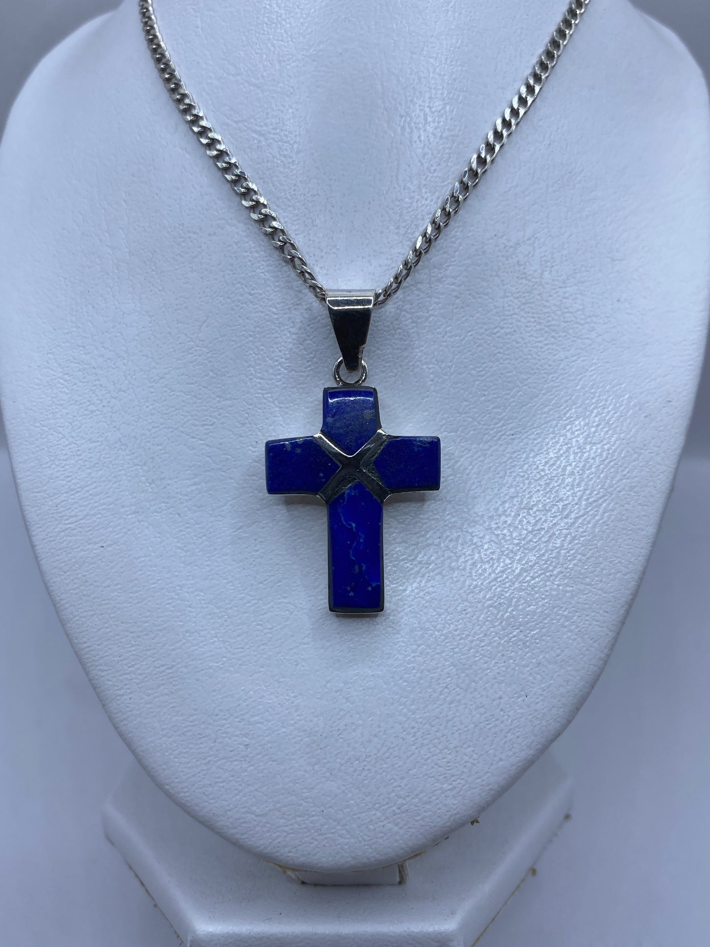 Cruz de lapislázuli engastada en plata vista de frente, mostrando la incrustación de piedra