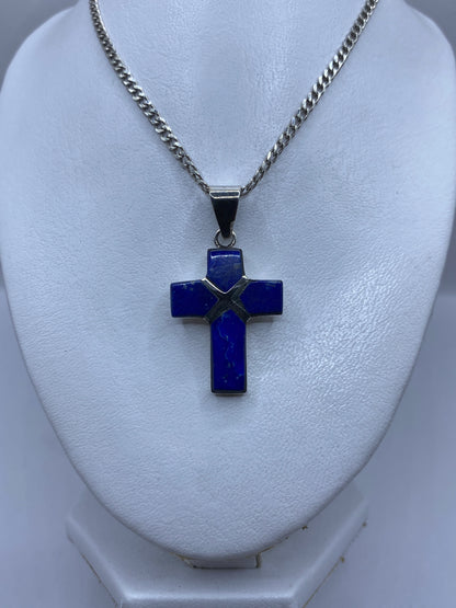 Cruz de lapislázuli engastada en plata vista de frente, mostrando la incrustación de piedra