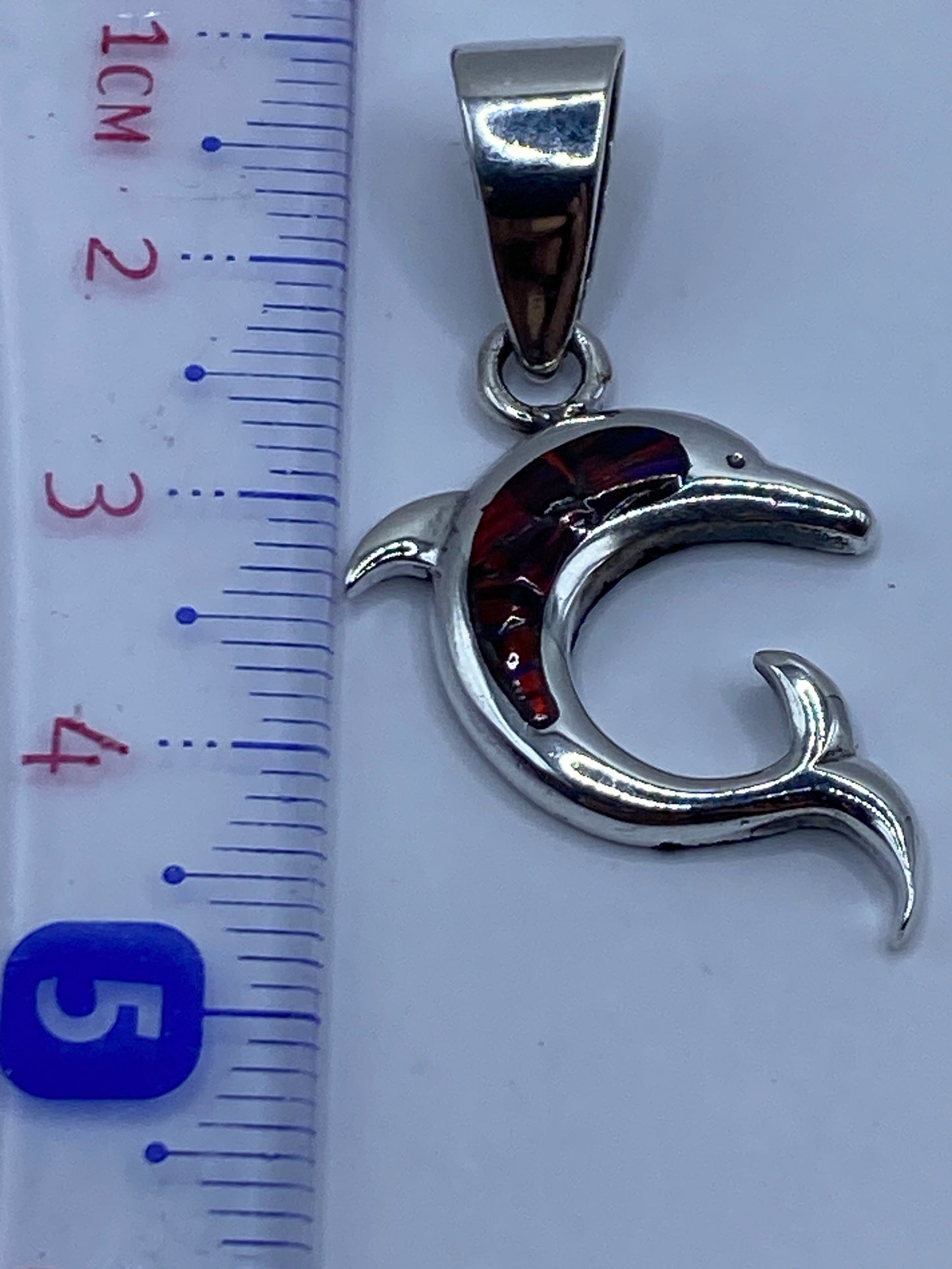 Dije de delfín sobre escala mostrando el Quinto 950 y peso de 3.7 g
