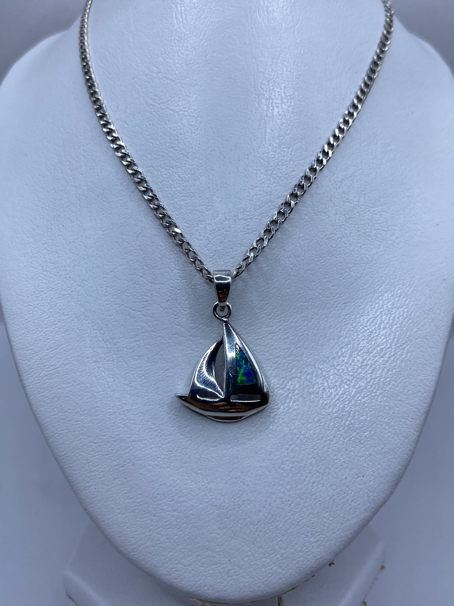 Dije de plata en forma de barco velero con piedra ópalo de fuego engastada, detalle lateral