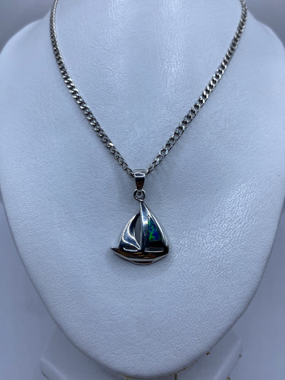 Dije de plata en forma de barco velero con piedra ópalo de fuego engastada, detalle lateral
