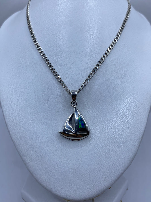 Dije de plata en forma de barco velero con piedra ópalo de fuego engastada, detalle lateral