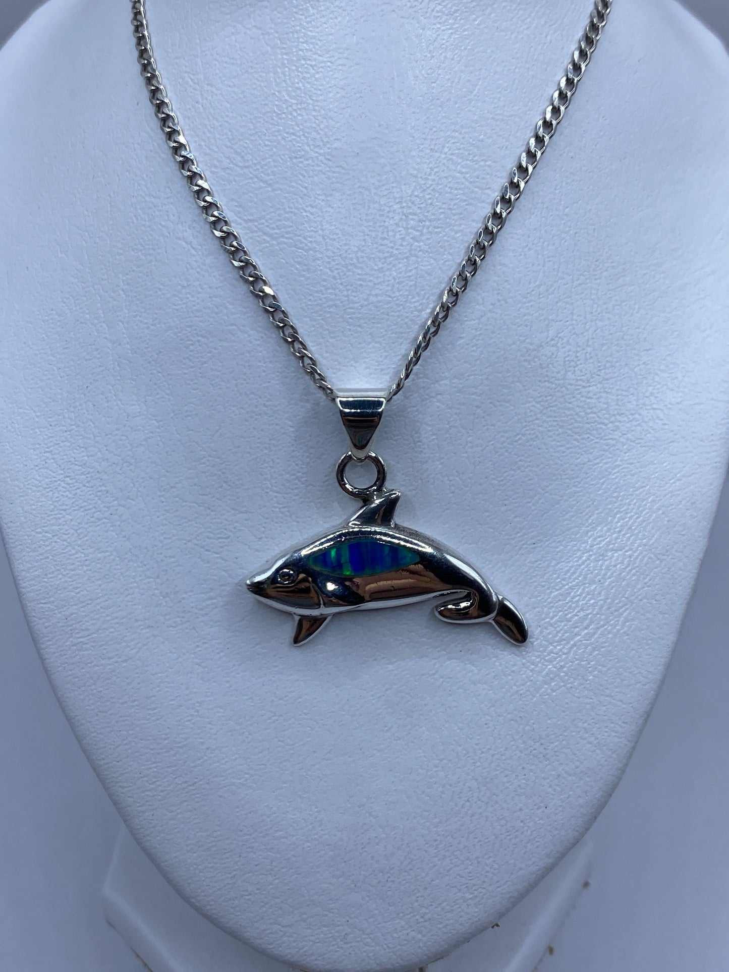 Detalle del ópalo de fuego azul iridiscente en el dije de orca