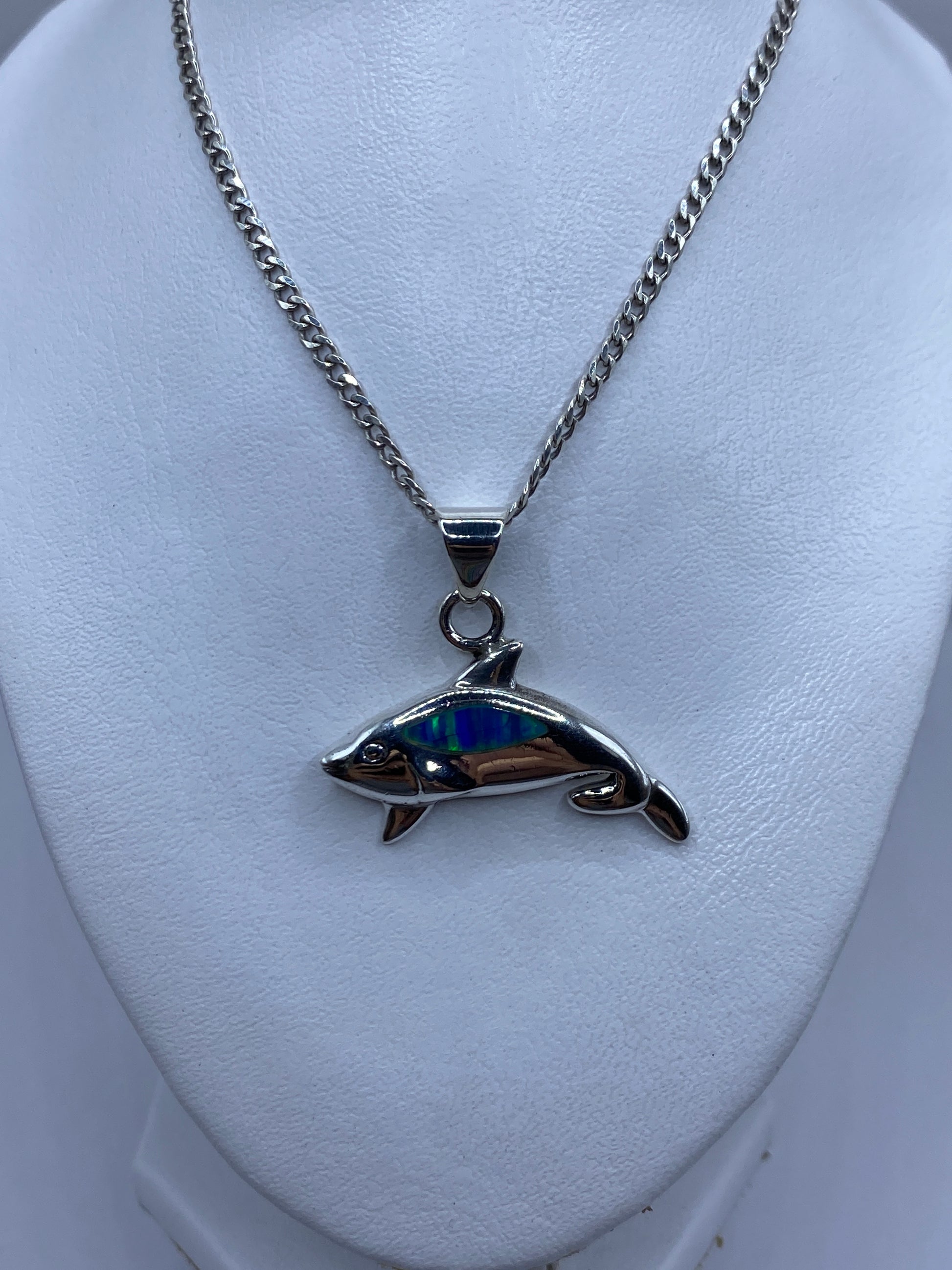Detalle del ópalo de fuego azul iridiscente en el dije de orca
