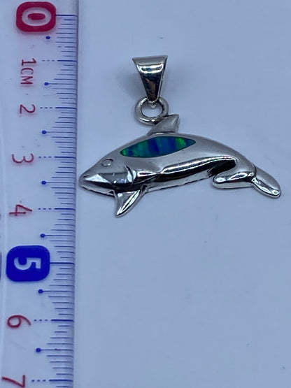 Dije orca de plata sobre fondo gris mostrando el Quinto .925