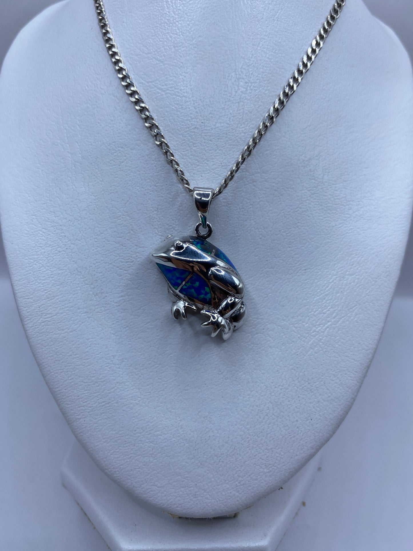 Detalle del ópalo de fuego azul engastado a mano en plata, mostrando reflejos verdes