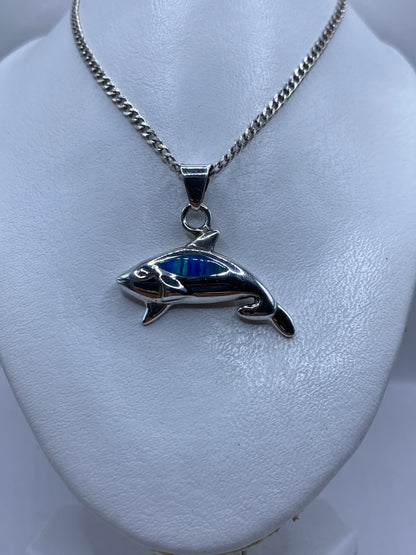 Dije de ballena de plata de Taxco en la mano, mostrando el tamaño real de 3.9 cm