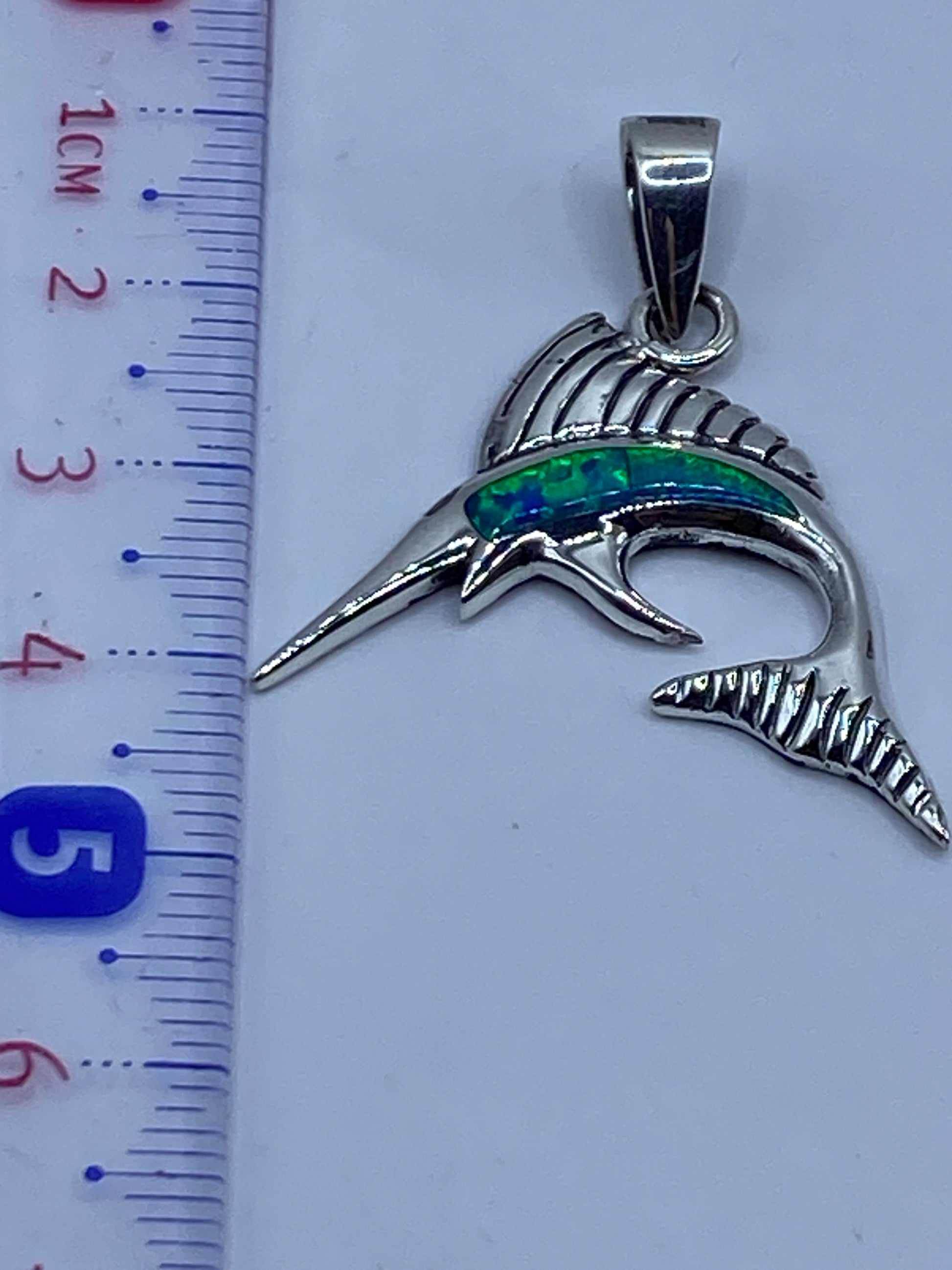 Reverso del dije marlin mostrando el Quinto .950 y la textura de fundición