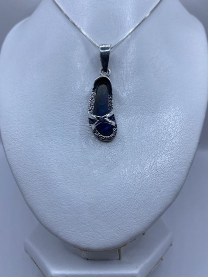 Detalle del ópalo de fuego en tonos azul profundo en el dije de plata