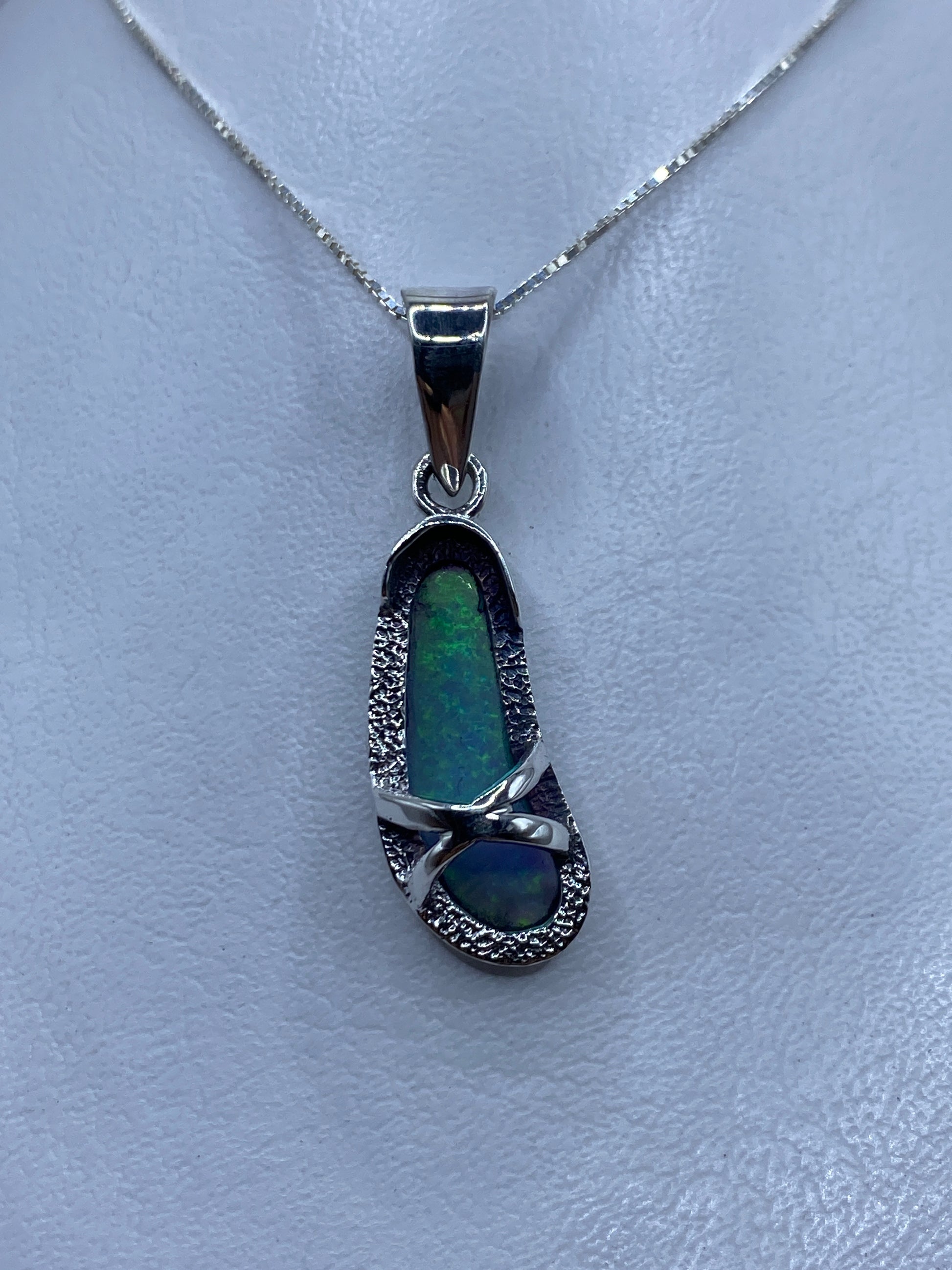 Dije de plata con ópalo de fuego azul cielo engastado, colgando de una cadena plateada