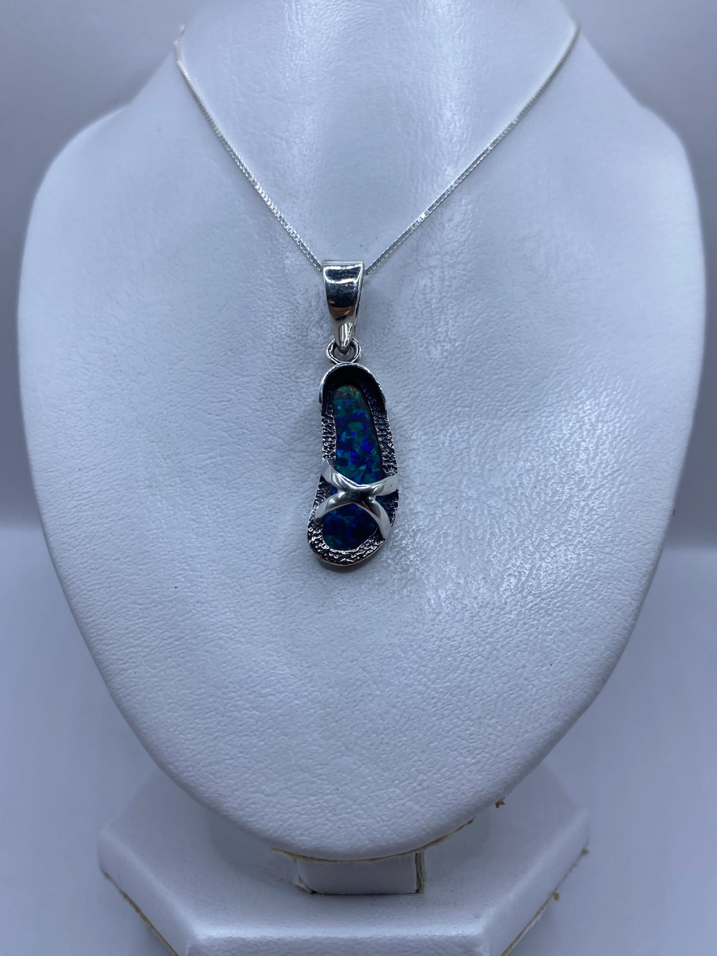 Detalle del engaste a mano del ópalo azul en plata .950, mostrando el trabajo artesanal