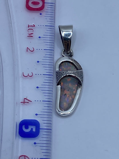 Dije de ópalo de fuego en plata .950 sobre regla de centímetros, evidenciando tamaño de 4.3 cm