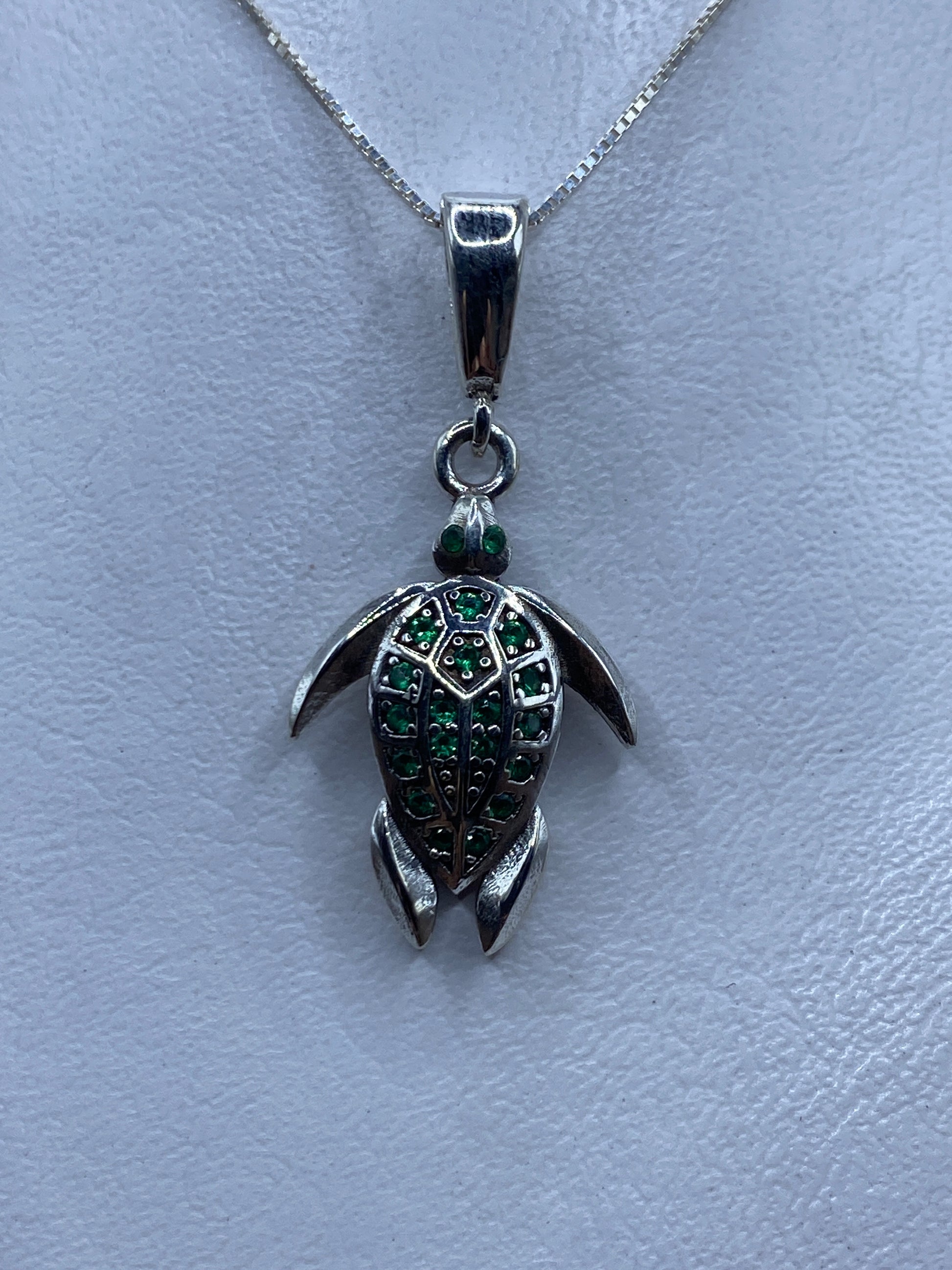 Dije tortuga de plata .925 con circonia verde engastada, colgando de cadena