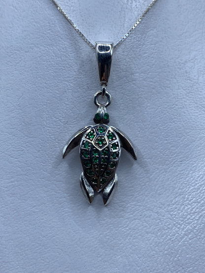Dije tortuga de plata .925 con circonia verde engastada, colgando de cadena