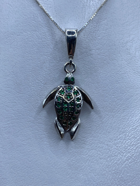 Dije tortuga de plata .925 con circonia verde engastada, colgando de cadena