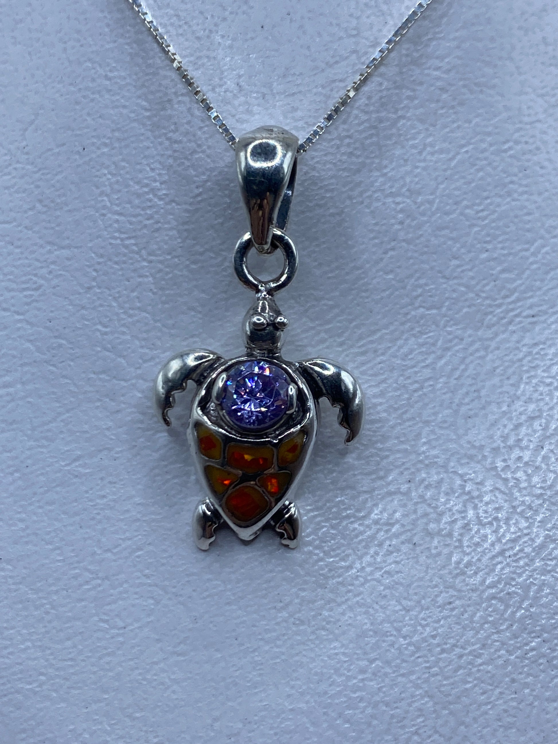 Dije tortuga en plata .925 con ópalo de fuego naranja, colgando de una cadena de plata