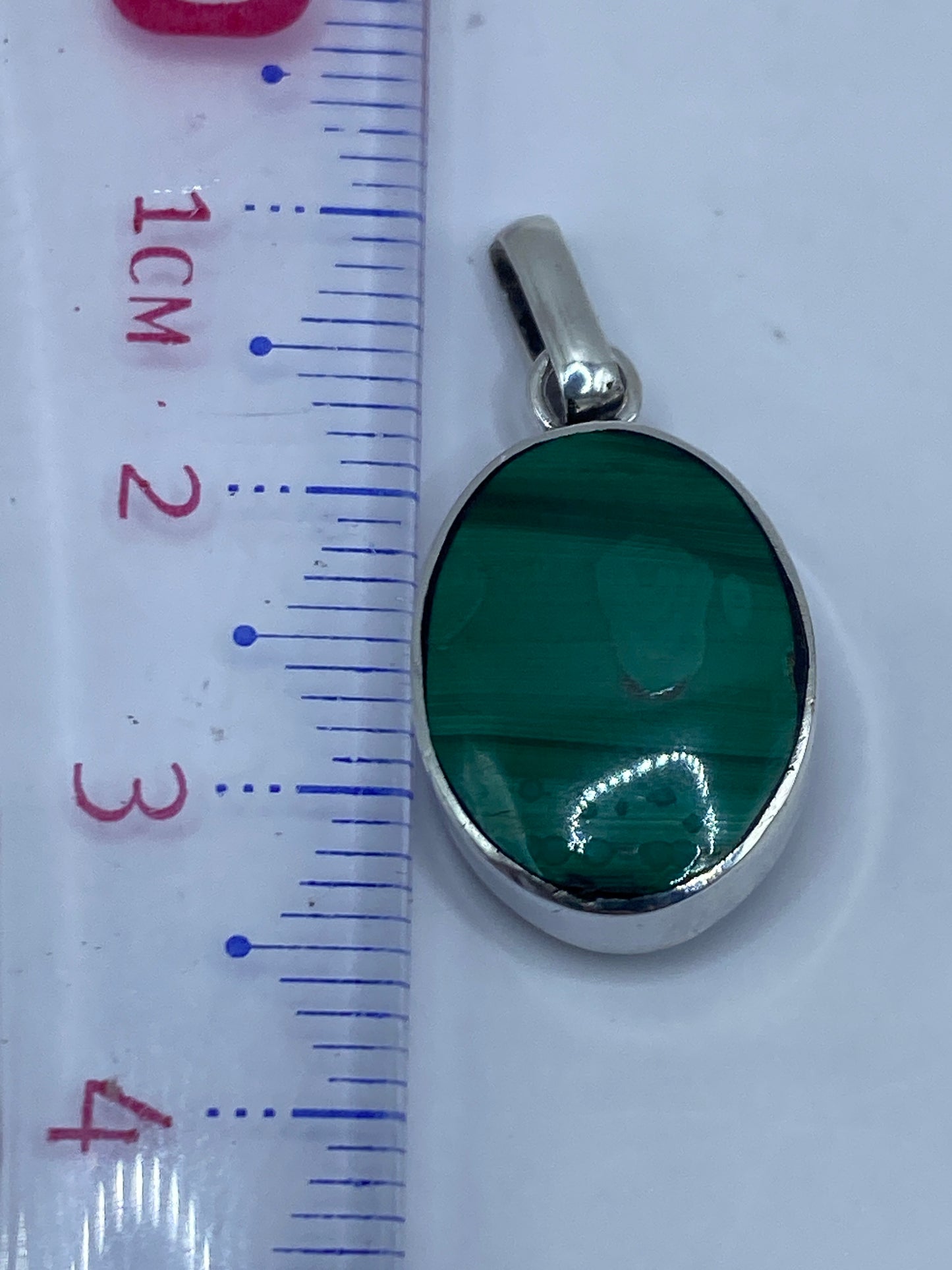 Dije de malaquita y plata sobre piel clara, mostrando proporción de uso