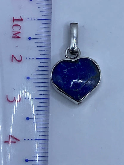 Dije de malaquita sobre regla métrica mostrando largo de 3.1 cm, con peso de 1.9 g en balanza