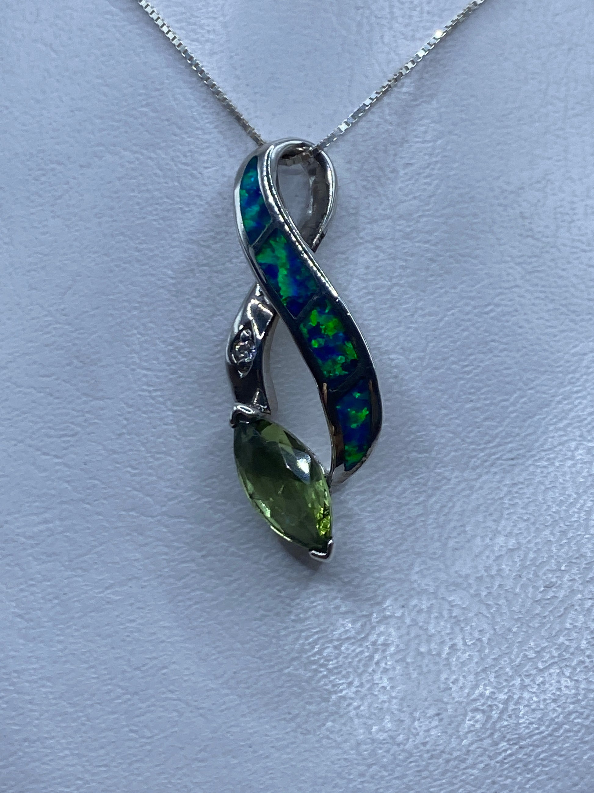 Dije de plata con ópalo de fuego azul multicolor colgado en cadena de plata brillante