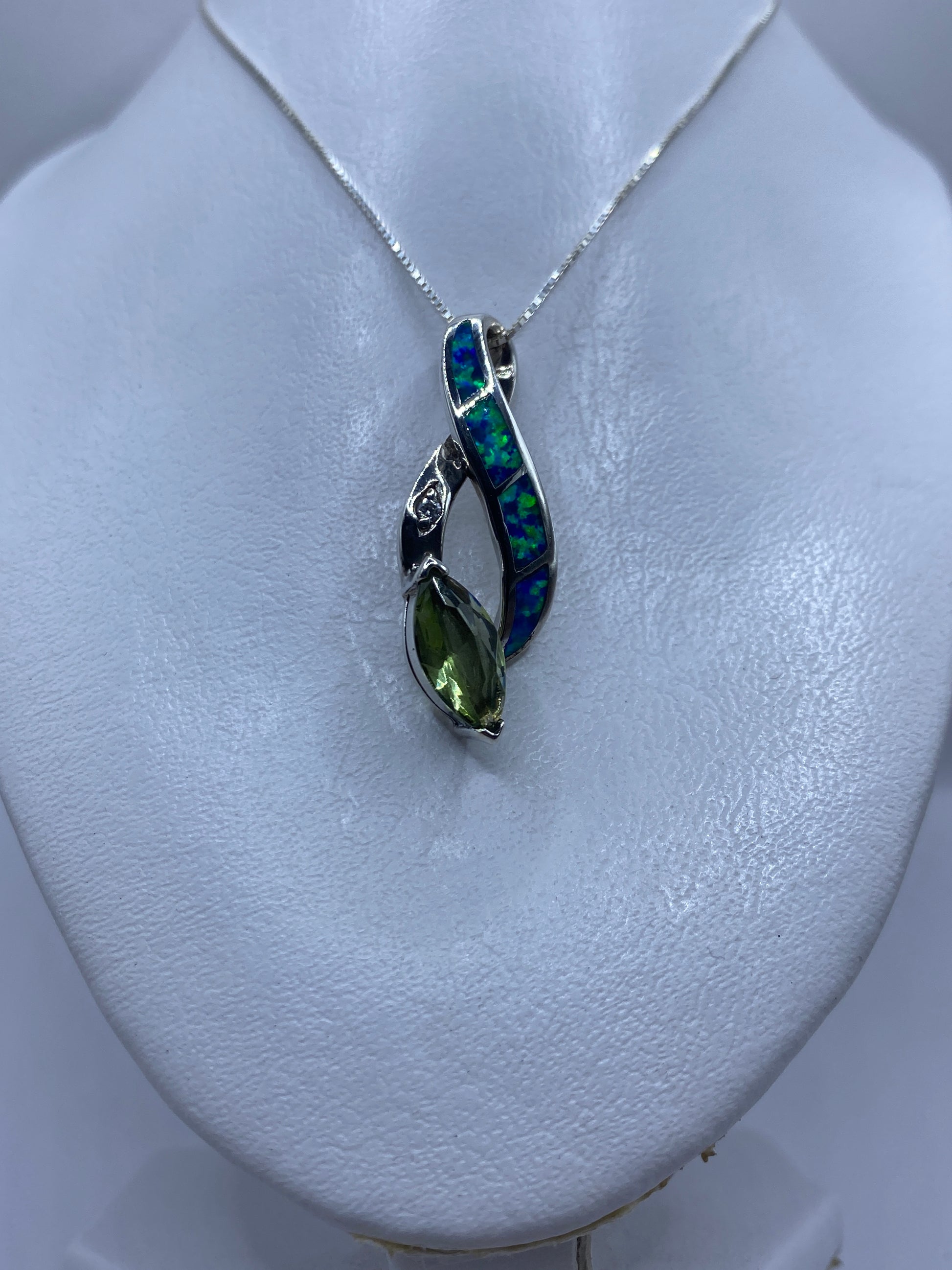 Detalle del ópalo azul reflejando luz verde y azul en engaste de plata .925