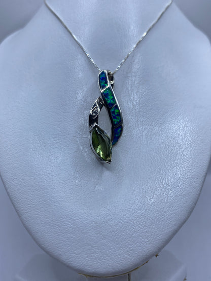 Detalle del ópalo azul reflejando luz verde y azul en engaste de plata .925