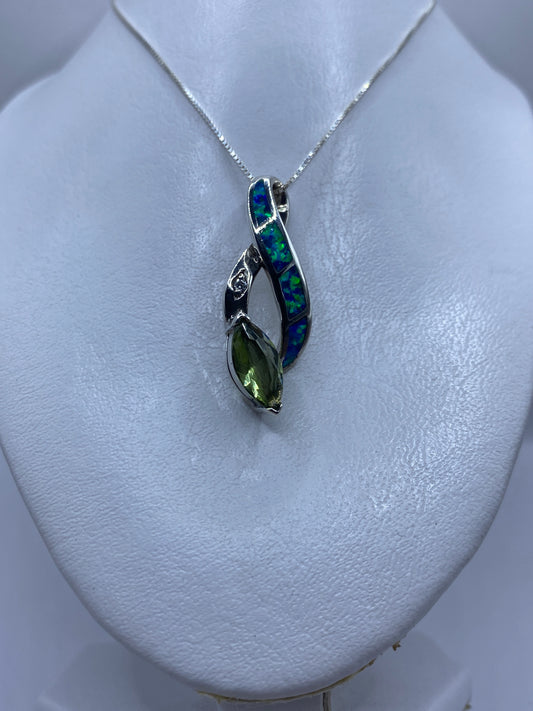 Detalle del ópalo azul reflejando luz verde y azul en engaste de plata .925