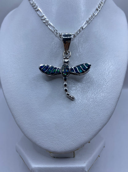 Detalle frontal de la libélula: ópalo de fuego azul engastado en el cuerpo, con granulado en las alas