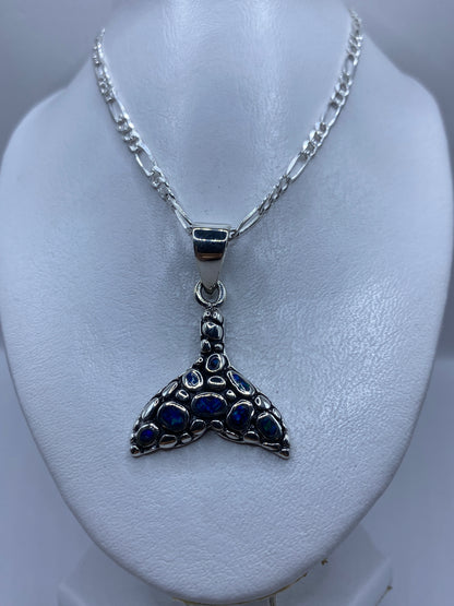 Detalle del ópalo de fuego azul engastado en la cola de ballena de plata