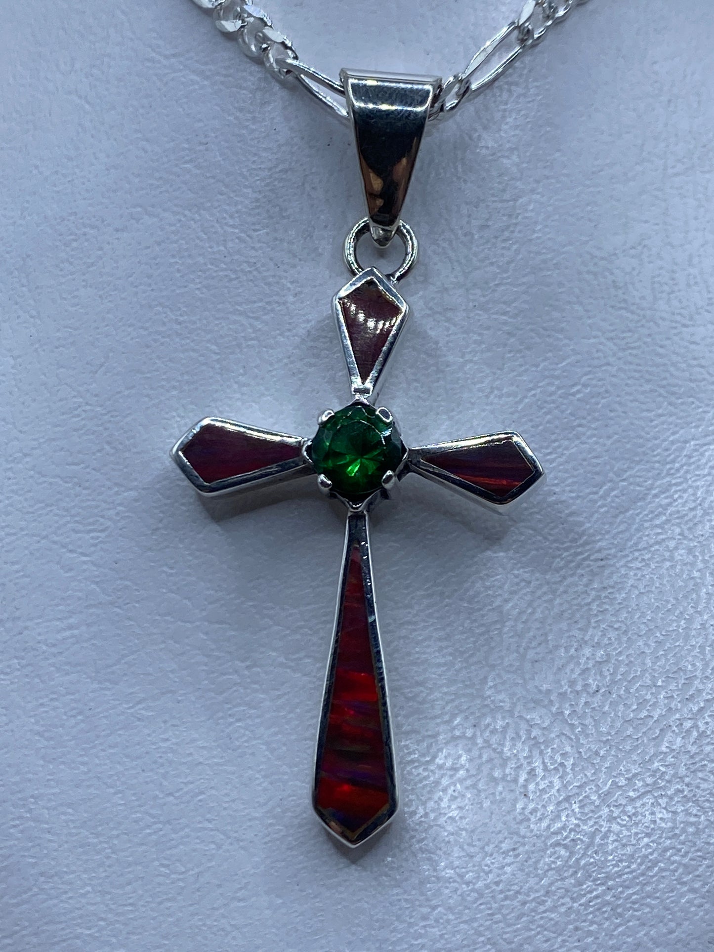 Dije cruz de plata .950 con Ópalo de Fuego multicolor, colgando de cadena figaro sobre pecho