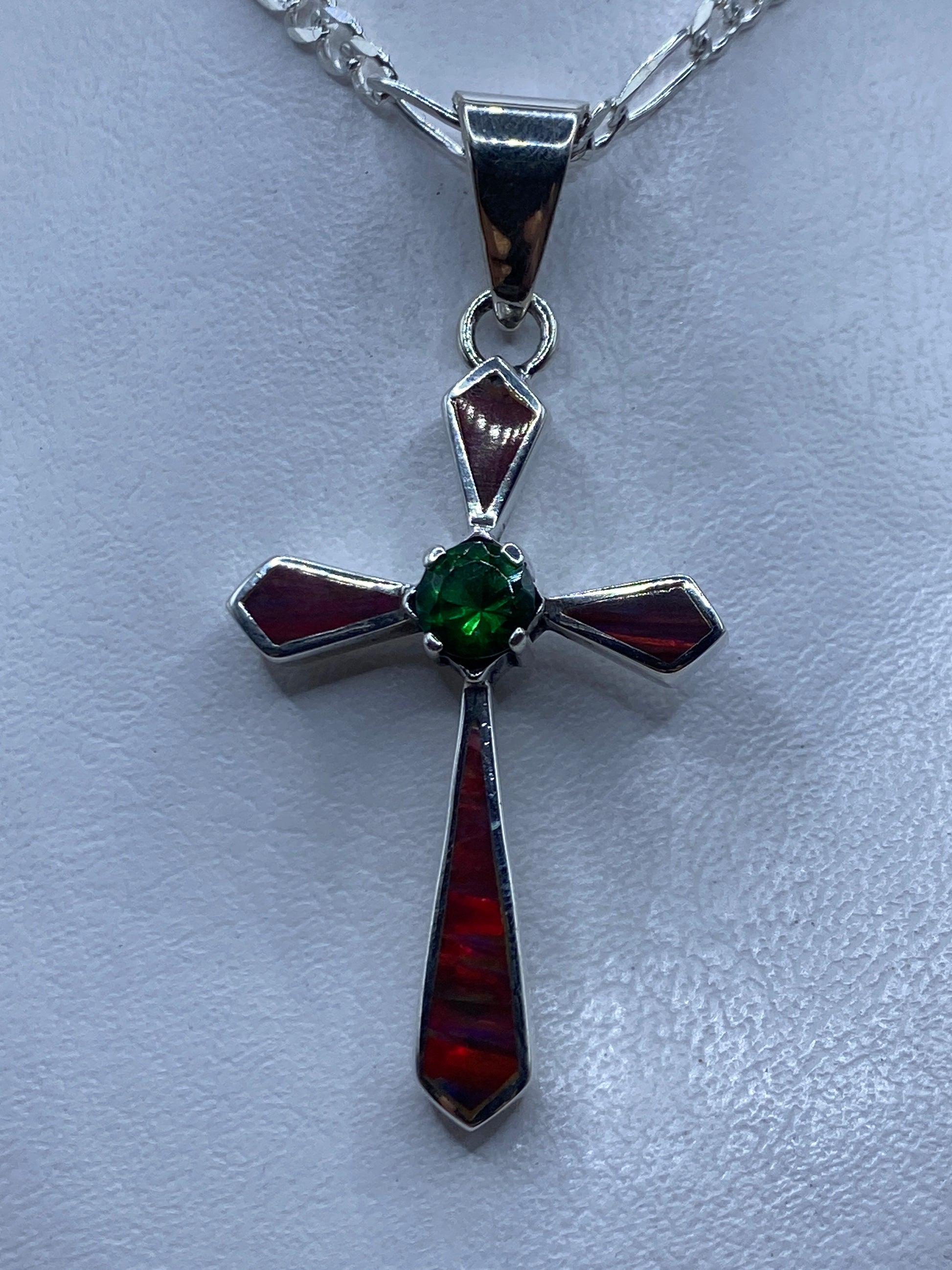 Dije cruz de plata .950 con Ópalo de Fuego multicolor, colgando de cadena figaro sobre pecho