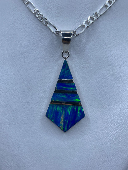 Dije de plata con ópalo de fuego azul e iridiscencias verdes, forma pentagonal, sobre cadena plateada
