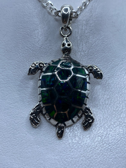 Dije de tortuga en plata .950 con ópalo de fuego verde incrustado, colgando de cadena