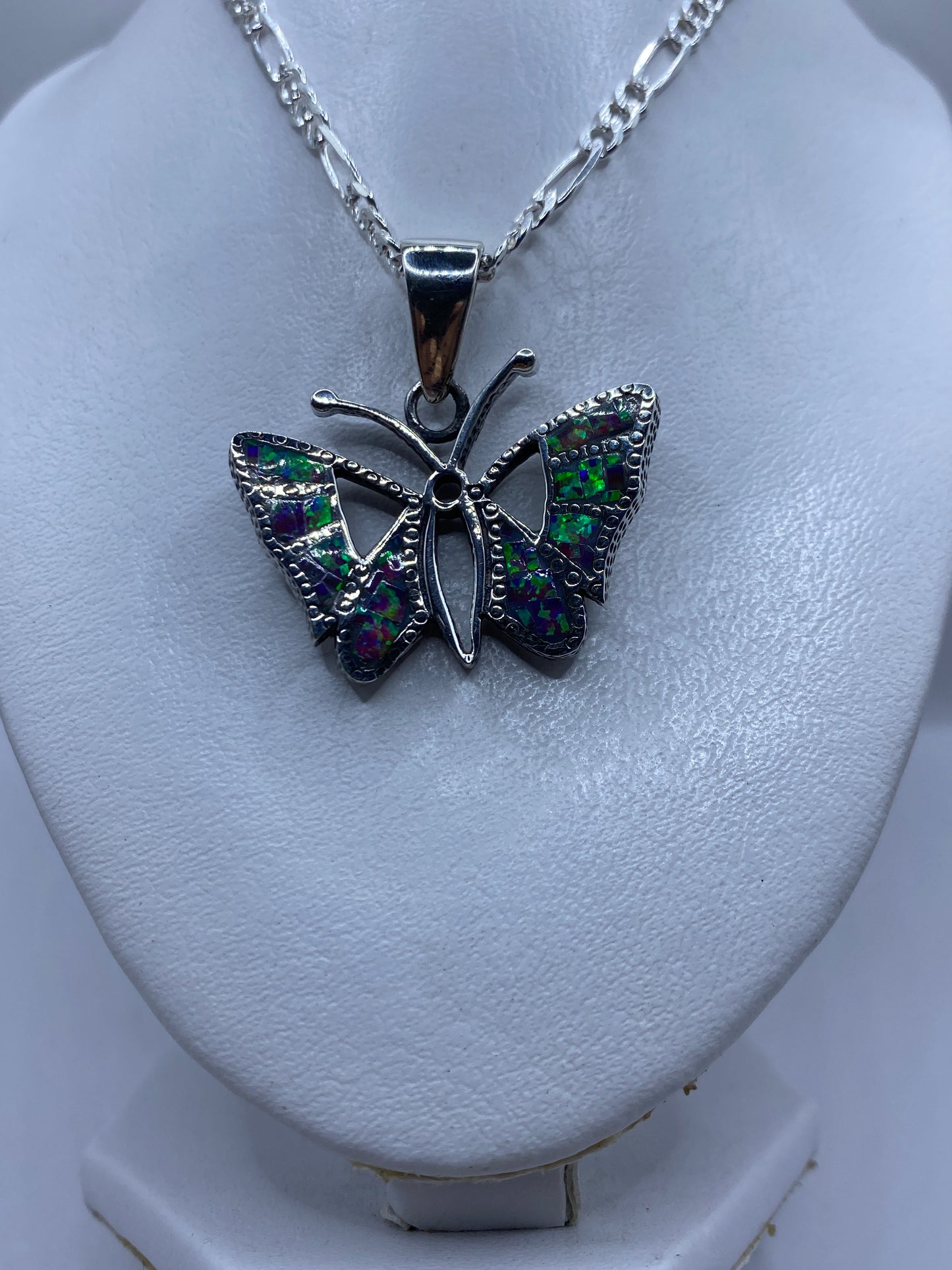 Detalle del ópalo de fuego con tonos verdes, púrpuras y azules en las alas de la mariposa