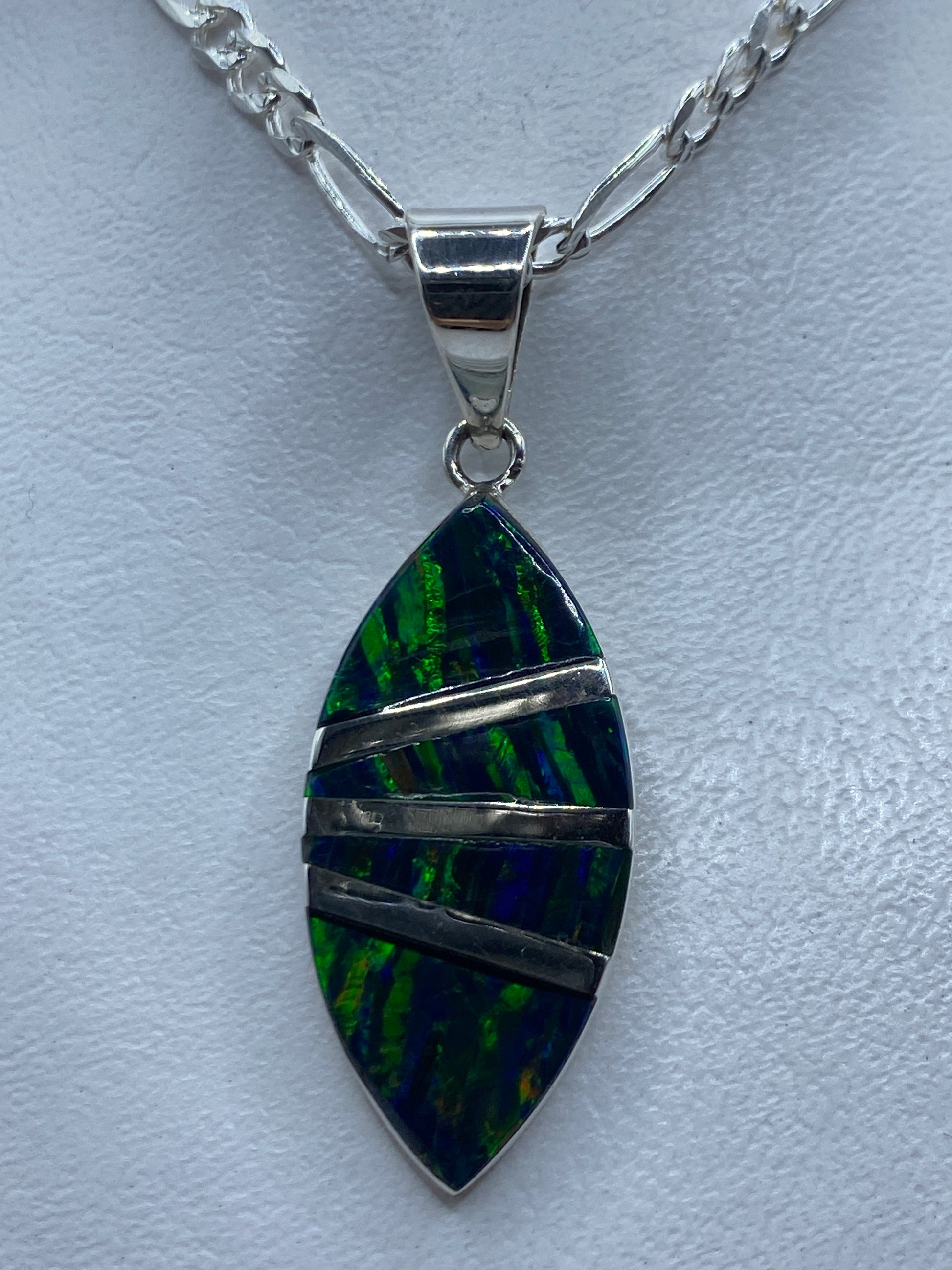 Dije de plata .950 con Ópalo de Fuego verde veteado, forma de hoja, colgado de una cadena plateada figaro
