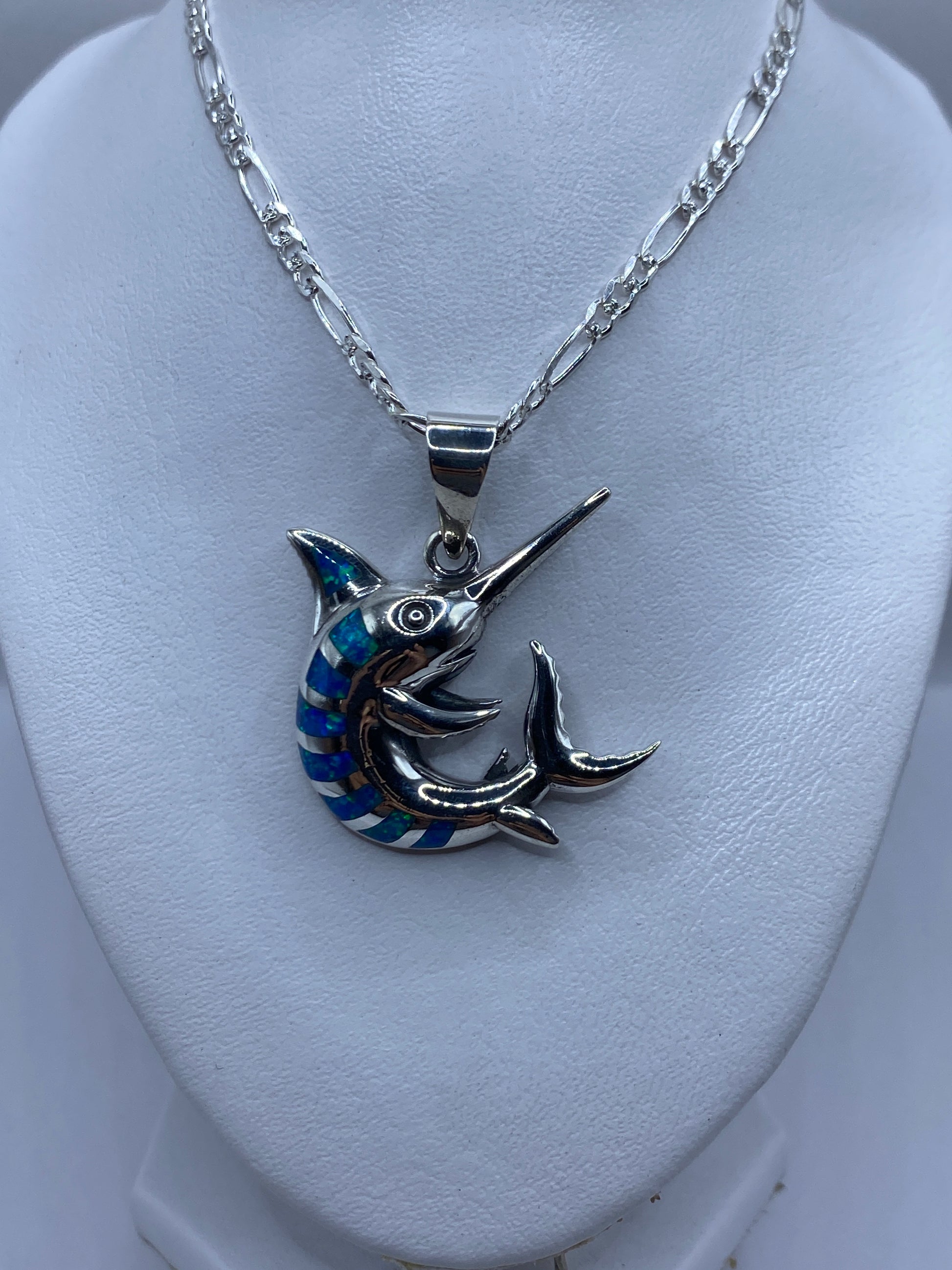 Dije marlin plateado mostrando la incrustación de piedra ópalo