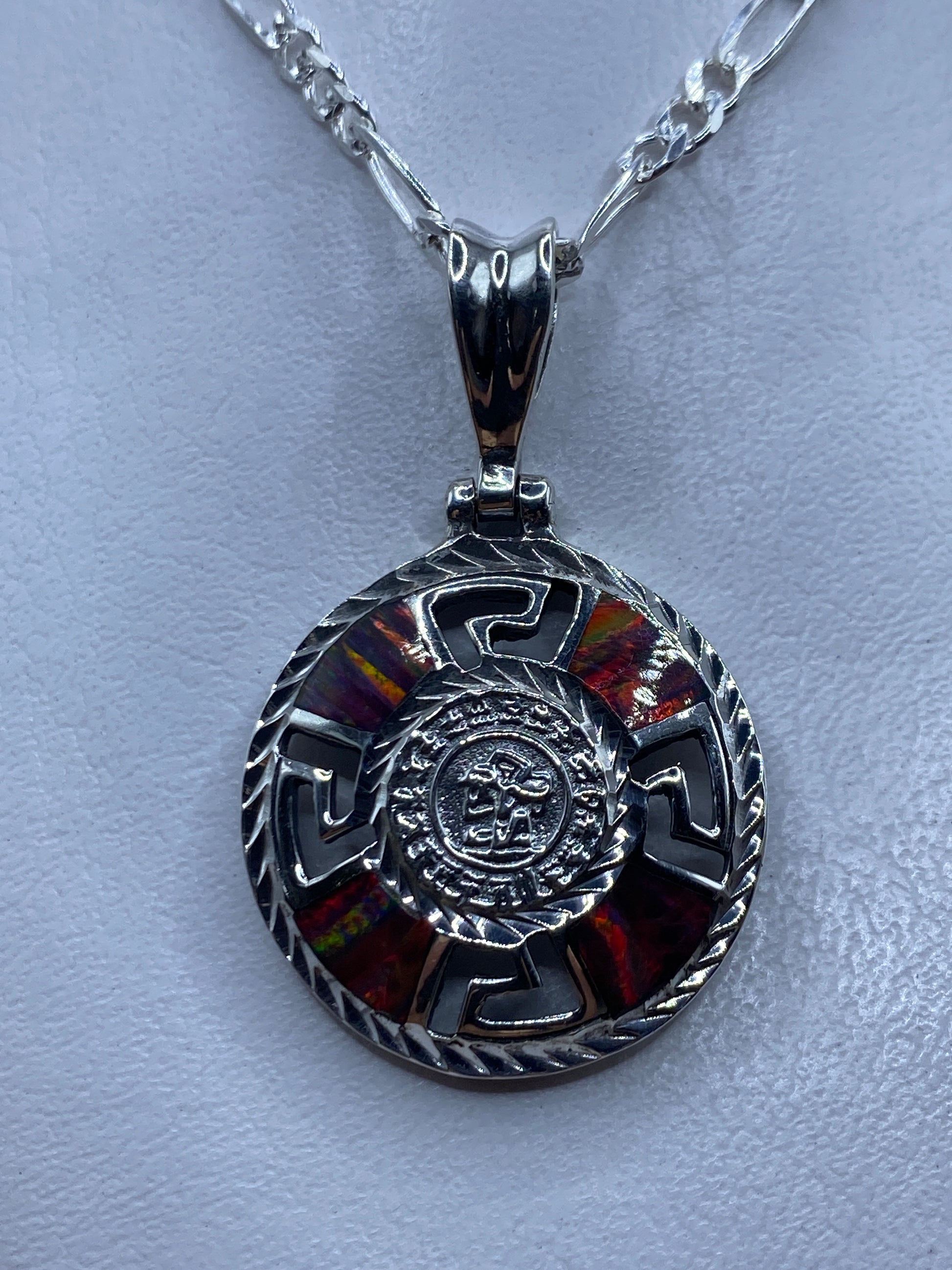 Dije prehispánico de plata .950 con ópalo de fuego multicolor y cadena de plata, colgado sobre fondo blanco