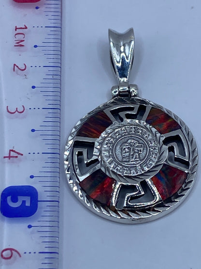Dije de 5.5 cm al lado de una regla, sin cadena, mostrando el tamaño real del medallón