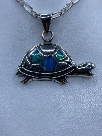 Dije tortuga de plata con Opalo de Fuego azul cielo engastado en el caparazón