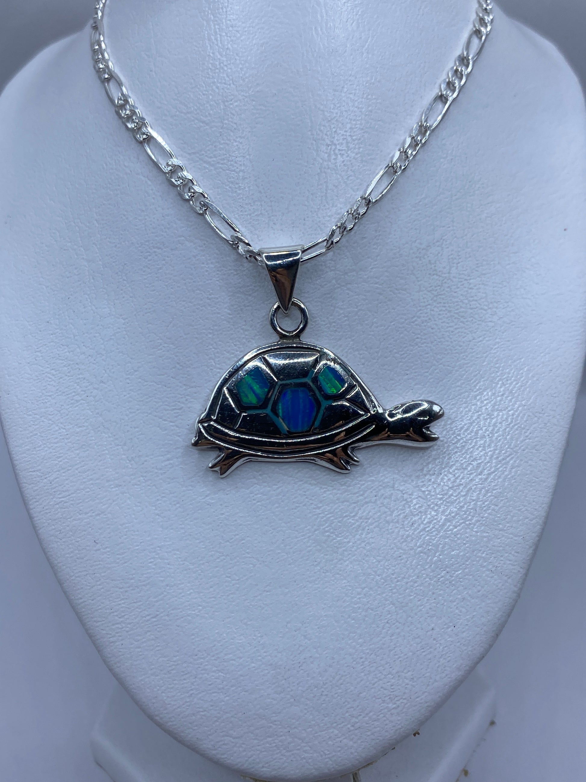 Detalle de cerca del Opalo de Fuego azul verdoso en la tortuga de plata