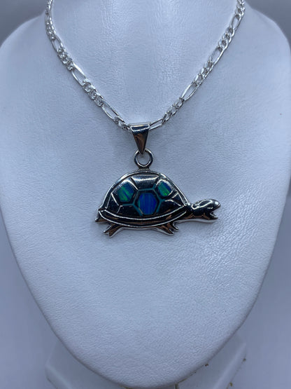 Detalle de cerca del Opalo de Fuego azul verdoso en la tortuga de plata