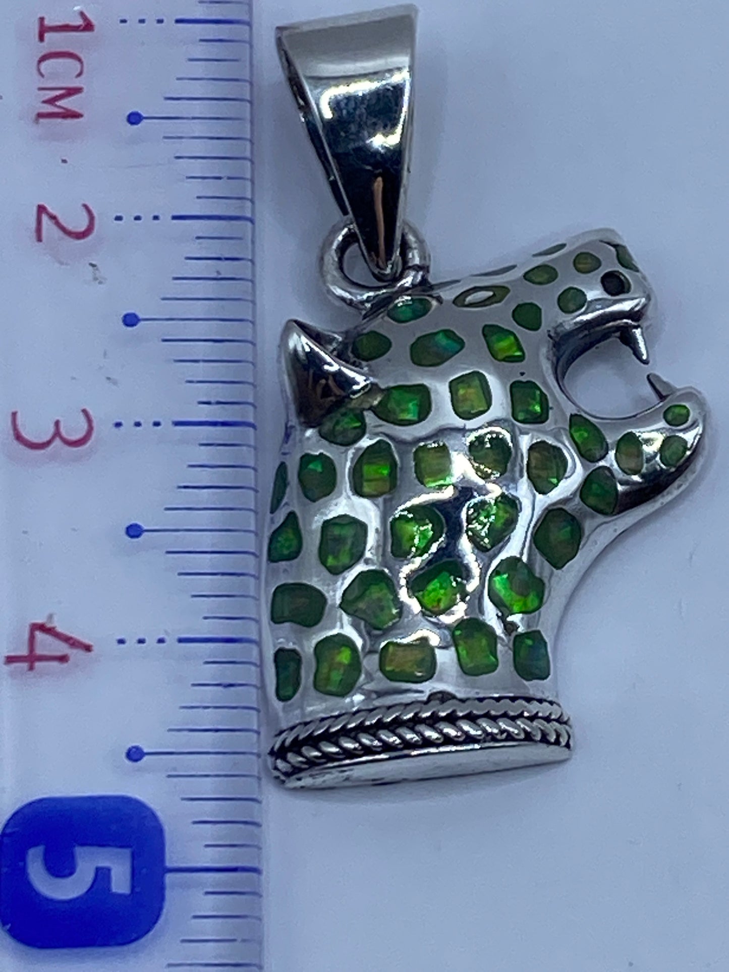 Dije junto a regla de centímetros, mostrando tamaño de 3.4 cm