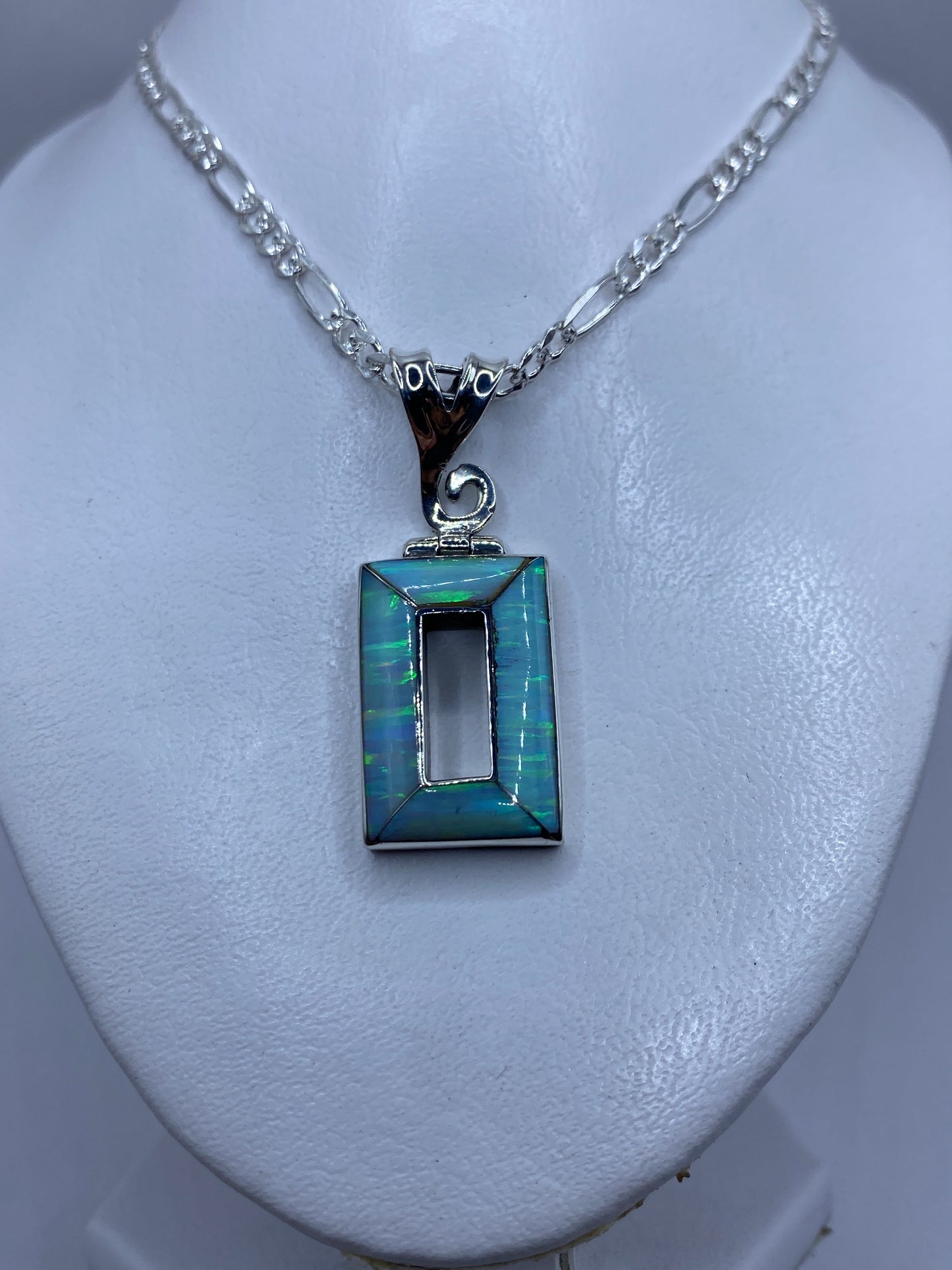 Detalle del ópalo de fuego engastado a mano en plata .950, mostrando reflejos azul cielo